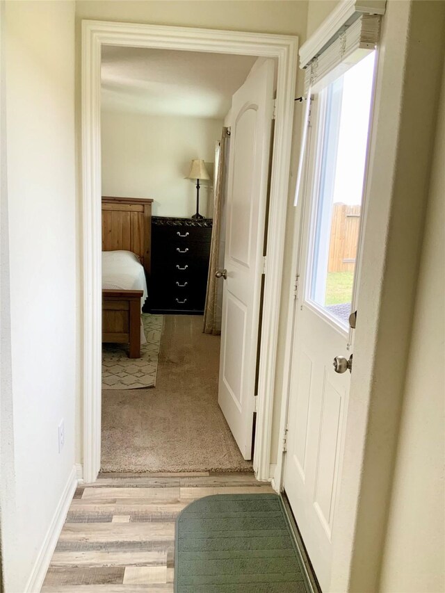 corridor with light hardwood / wood-style floors