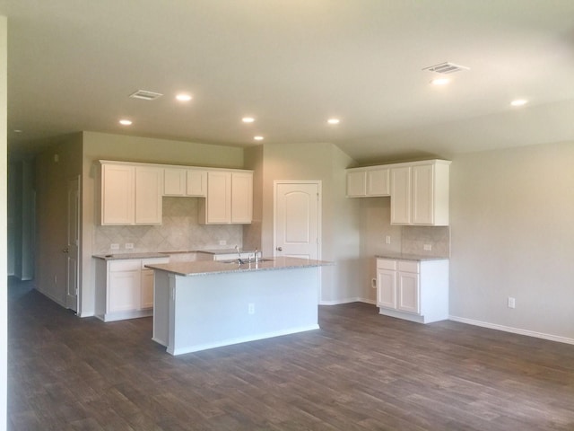 kitchen featuring white cabinets, a center island with sink, dark wood-type flooring, and sink