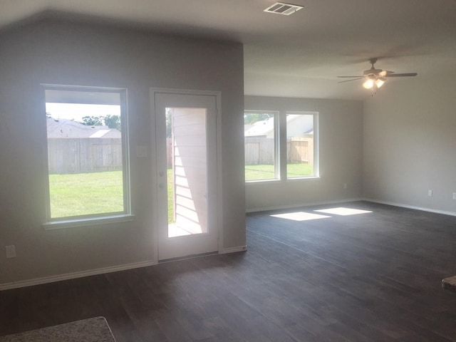 unfurnished room featuring ceiling fan, a healthy amount of sunlight, and dark wood-type flooring