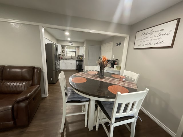 dining space with dark hardwood / wood-style floors and sink