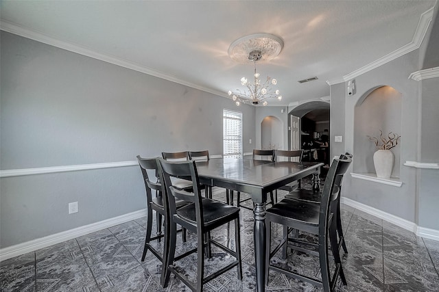 dining area featuring crown molding and an inviting chandelier