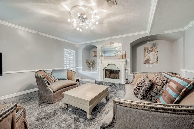 living room featuring crown molding, a textured ceiling, a high end fireplace, and an inviting chandelier