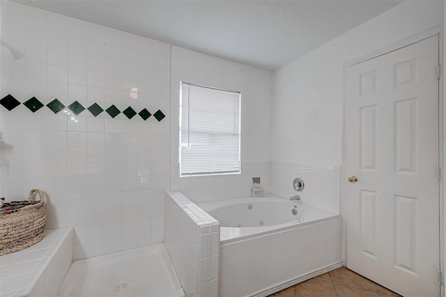 bathroom with tile patterned flooring and a relaxing tiled tub