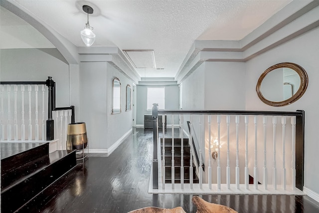 corridor featuring dark hardwood / wood-style flooring and a textured ceiling