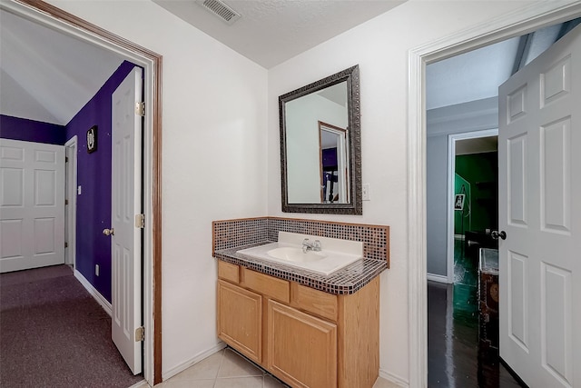 bathroom with tile patterned floors, vanity, and tasteful backsplash