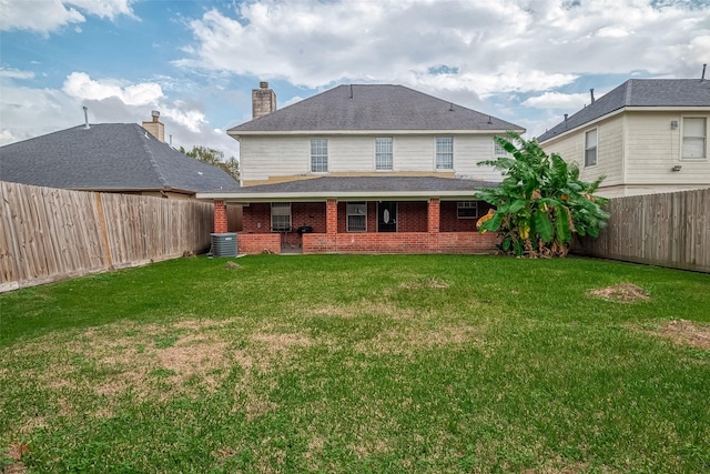 rear view of property featuring a yard and central AC unit