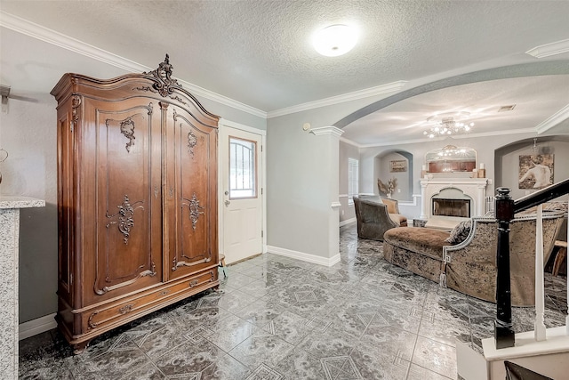 entryway with ornamental molding and a textured ceiling