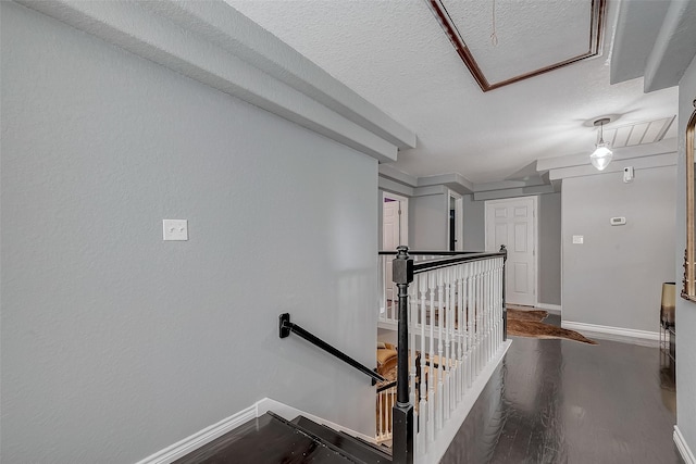 stairs with wood-type flooring and a textured ceiling