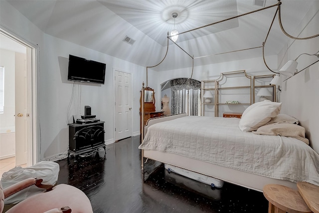 bedroom featuring a wood stove and lofted ceiling