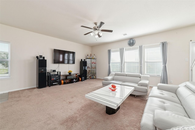 carpeted living room featuring plenty of natural light and ceiling fan