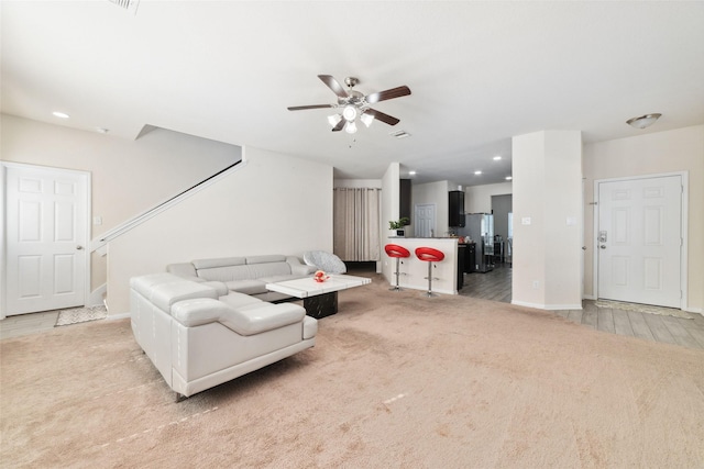 living room featuring ceiling fan and light colored carpet