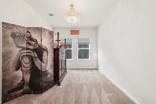 interior space featuring light carpet and an inviting chandelier