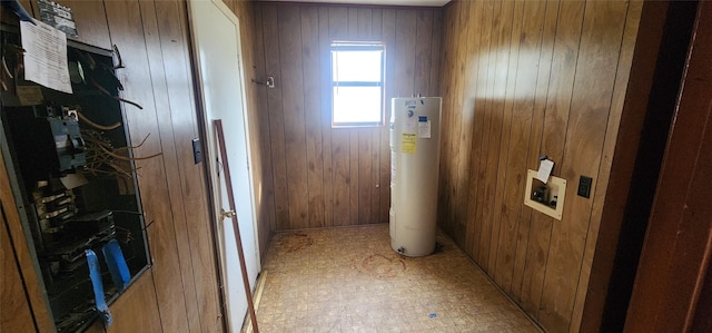 laundry area with washer hookup, water heater, and wood walls