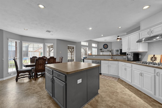 kitchen featuring white cabinets, a kitchen island, appliances with stainless steel finishes, and gray cabinets