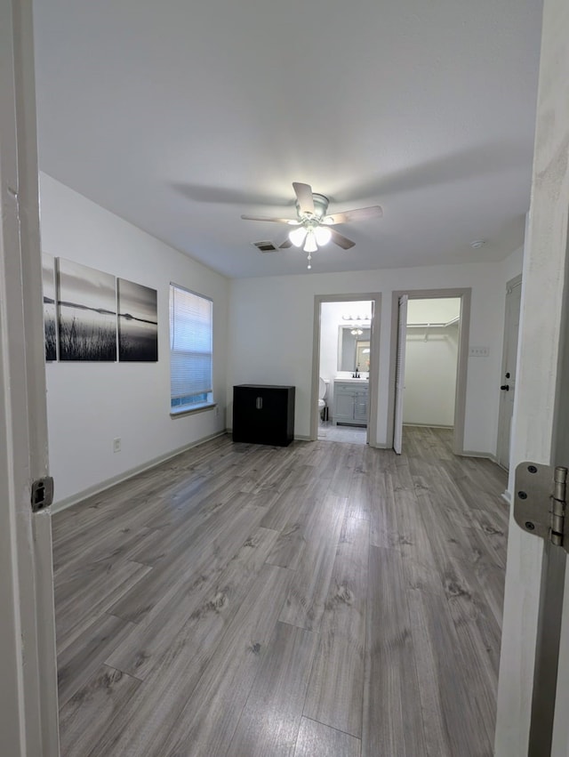 unfurnished living room featuring ceiling fan and light hardwood / wood-style floors