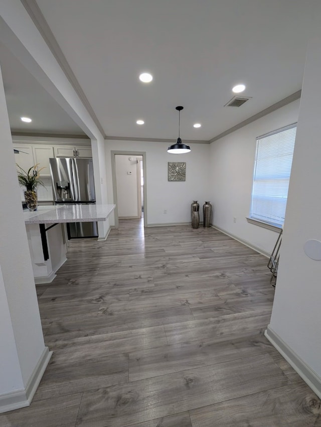 interior space with hardwood / wood-style flooring and crown molding