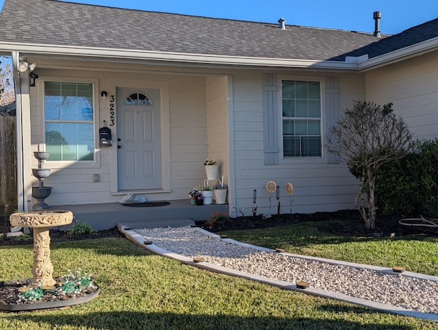 view of exterior entry with a yard