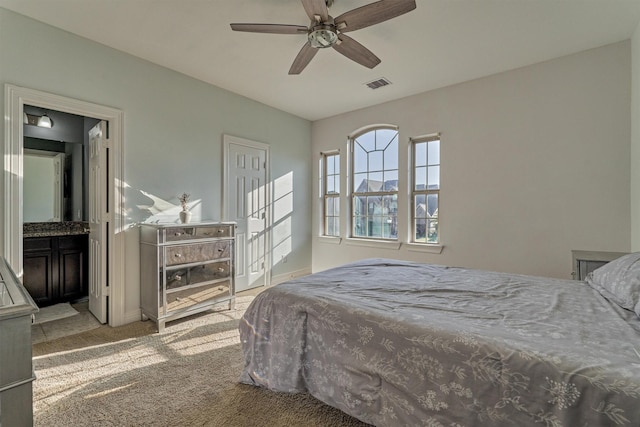 carpeted bedroom with connected bathroom and ceiling fan