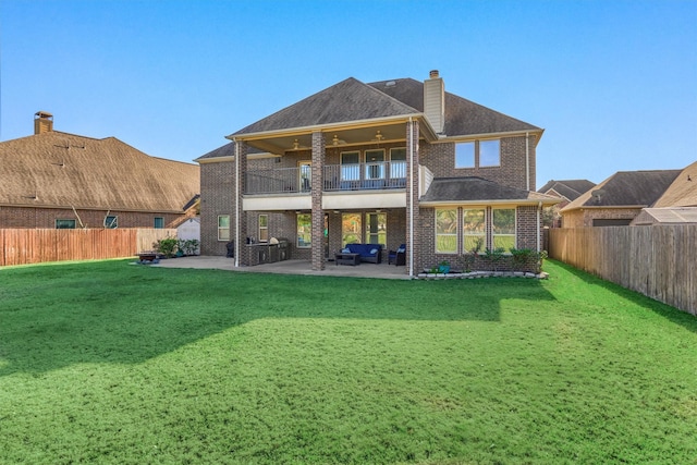 rear view of property with a yard, a patio, and a balcony