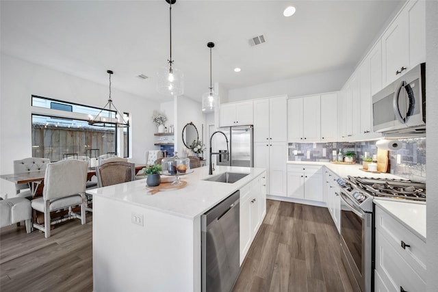 kitchen with a center island with sink, white cabinets, sink, and appliances with stainless steel finishes