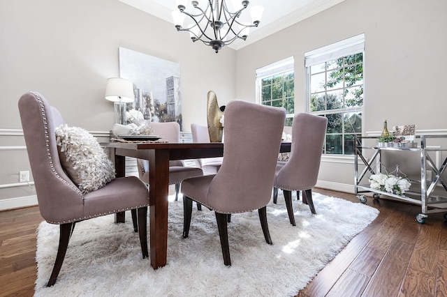 dining room featuring an inviting chandelier, ornamental molding, and hardwood / wood-style flooring