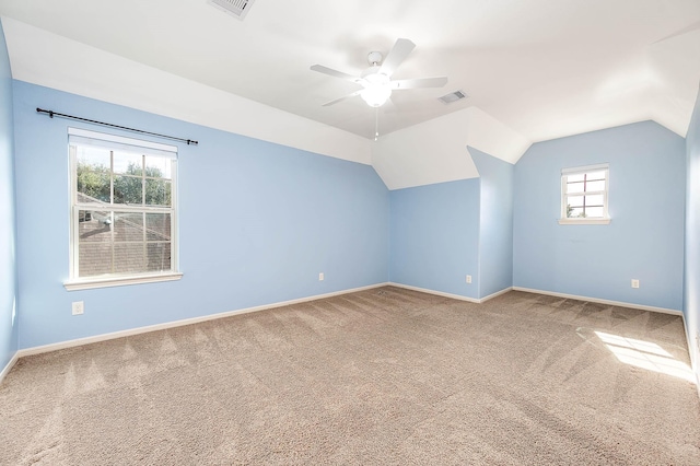 additional living space featuring lofted ceiling, ceiling fan, plenty of natural light, and carpet flooring