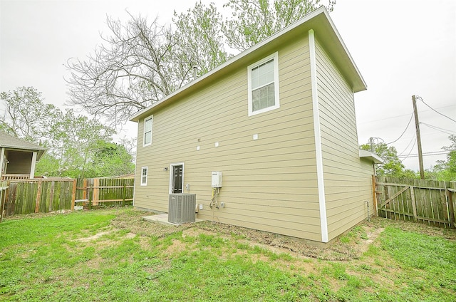 back of house featuring central AC and a lawn