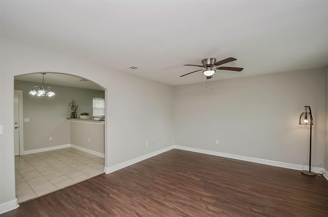 unfurnished room with light wood-type flooring and ceiling fan with notable chandelier