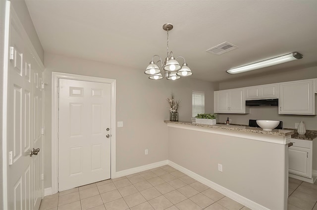 kitchen featuring white cabinets, decorative light fixtures, and kitchen peninsula