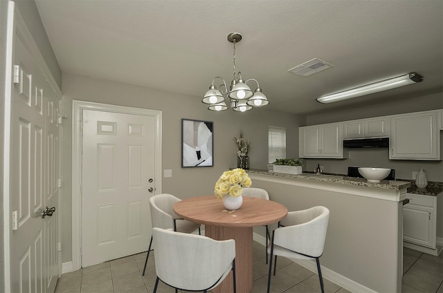 dining room with a chandelier and light tile patterned floors