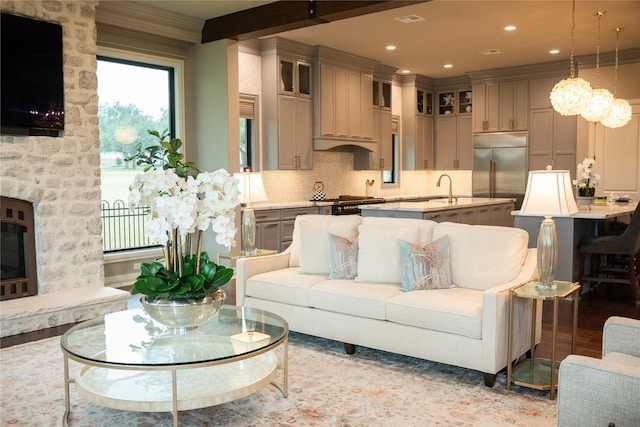 living room featuring light hardwood / wood-style floors, ornamental molding, and sink