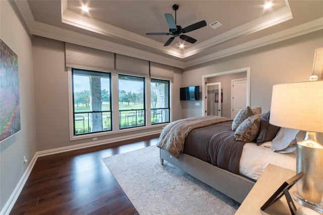 bedroom with ceiling fan, dark hardwood / wood-style flooring, a raised ceiling, and ornamental molding