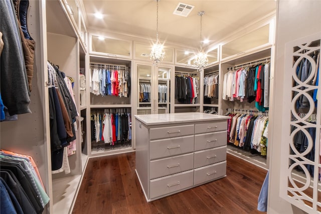 spacious closet featuring a notable chandelier and dark hardwood / wood-style floors