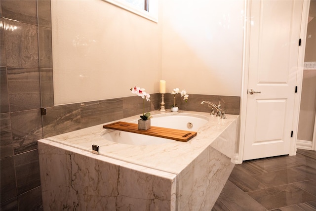 bathroom with tile patterned floors and tiled bath