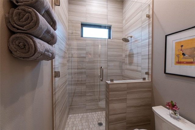 bathroom featuring toilet and an enclosed shower