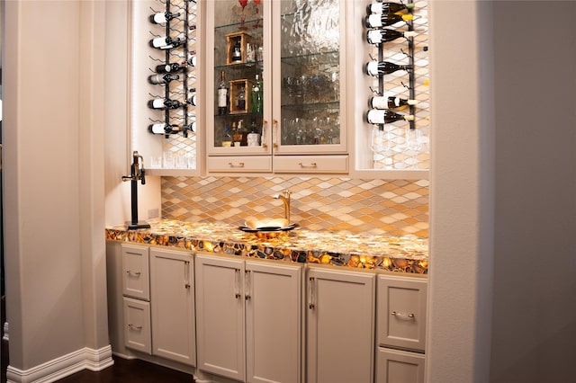 bar featuring backsplash and light stone counters