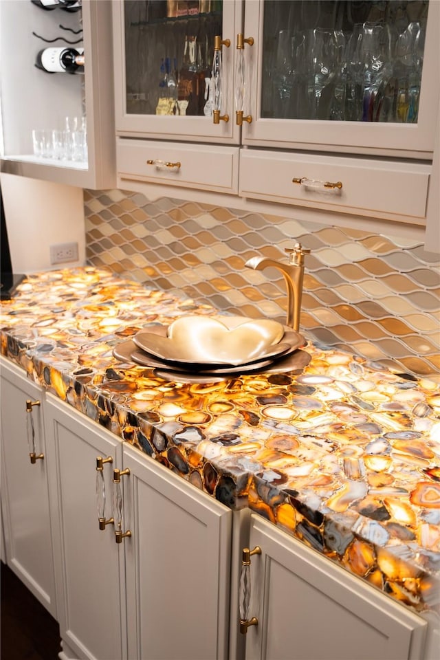 bar with backsplash and white cabinetry