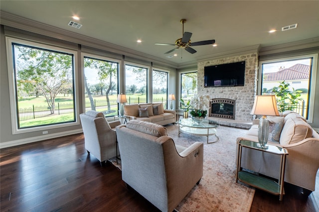 living room with ceiling fan, dark hardwood / wood-style floors, crown molding, and a brick fireplace