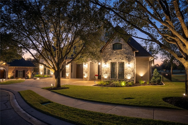 view of front of property with a garage and a yard