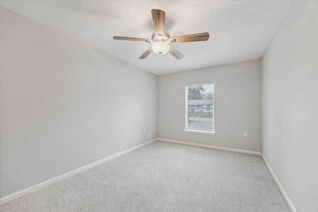 carpeted empty room with ceiling fan and a textured ceiling