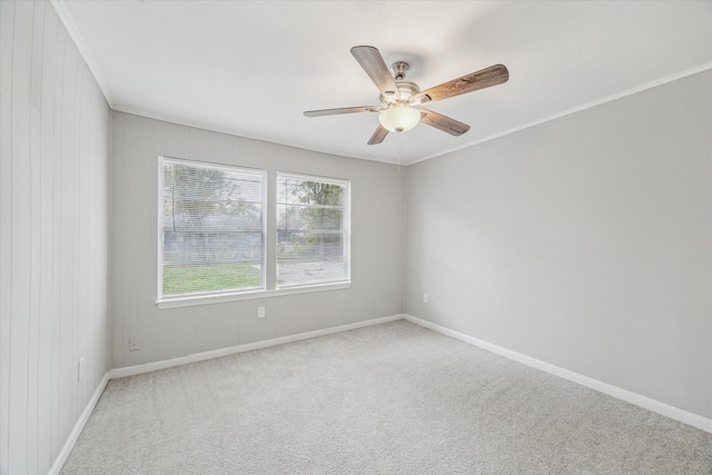 carpeted empty room featuring ceiling fan and crown molding