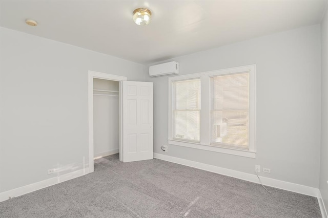 unfurnished bedroom with light carpet, a wall mounted AC, and a closet