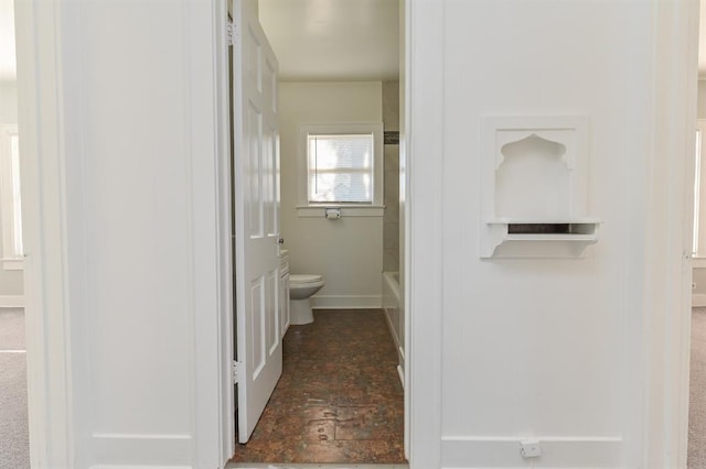 bathroom featuring toilet and a tub to relax in