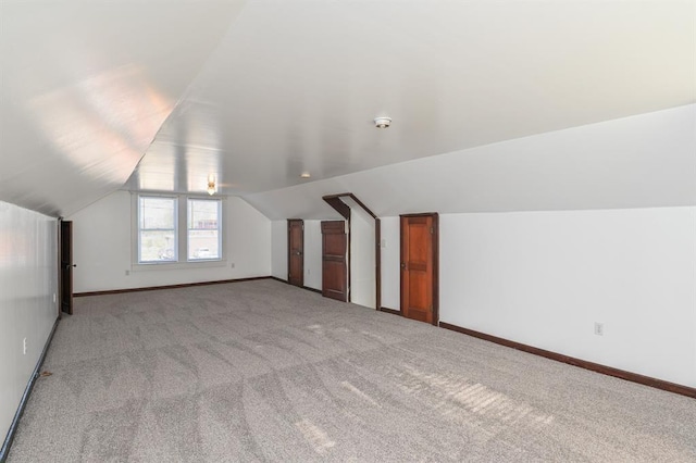 bonus room featuring light colored carpet and vaulted ceiling