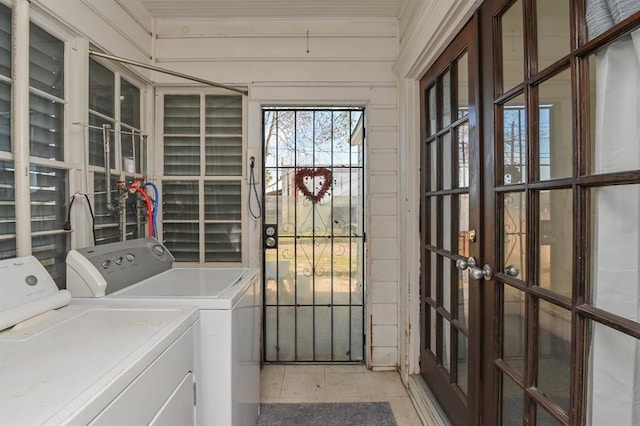 washroom with washing machine and clothes dryer and wooden walls