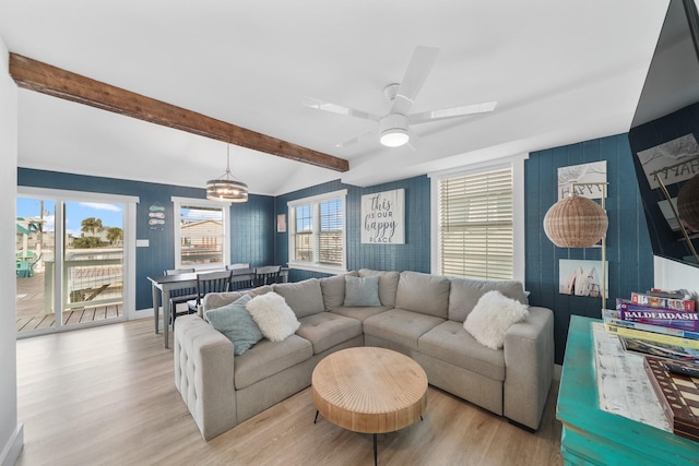 living room featuring vaulted ceiling with beams, light hardwood / wood-style flooring, and a healthy amount of sunlight