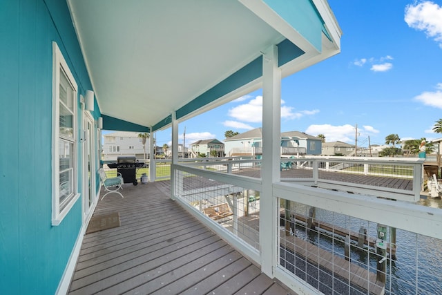 wooden terrace featuring a water view and area for grilling