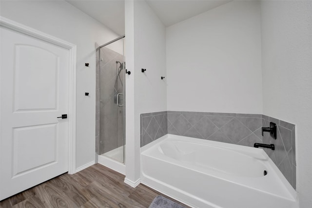 bathroom with hardwood / wood-style flooring and separate shower and tub