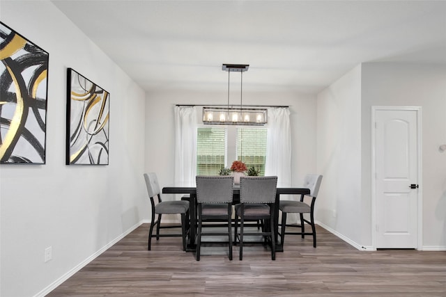 dining space with a notable chandelier and dark hardwood / wood-style floors