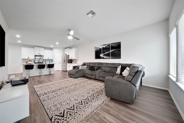 living room with sink, wood-type flooring, and ceiling fan